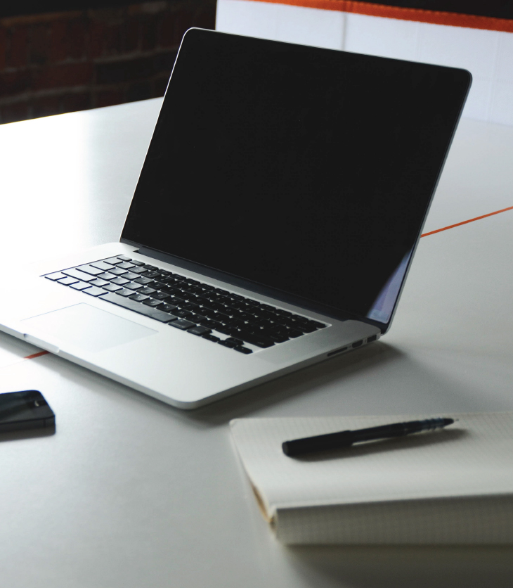 Laptop and notepad sitting on a desk